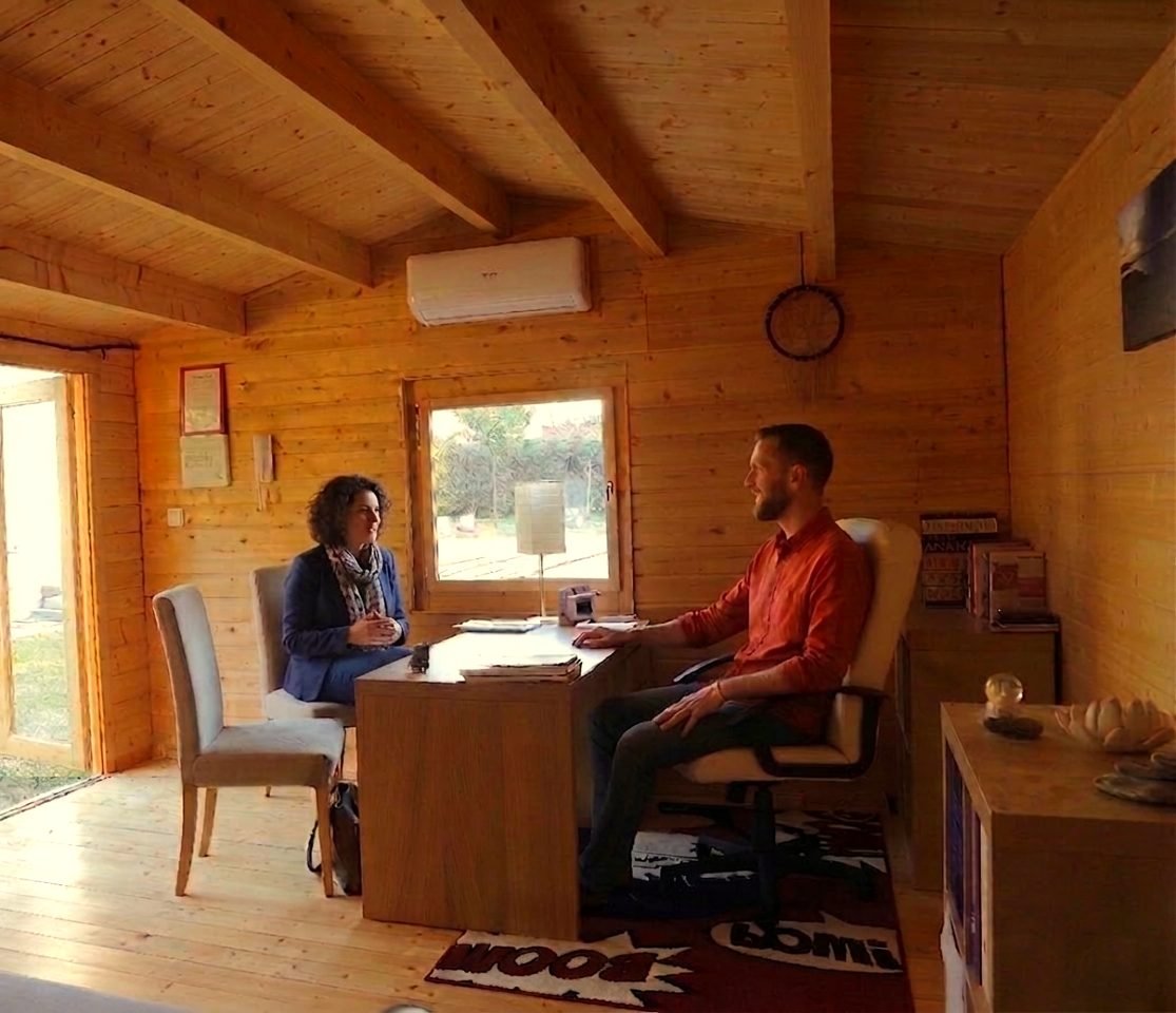 Jean-Baptiste Billy en consultation dans son cabinet en bois, échange avec une patiente